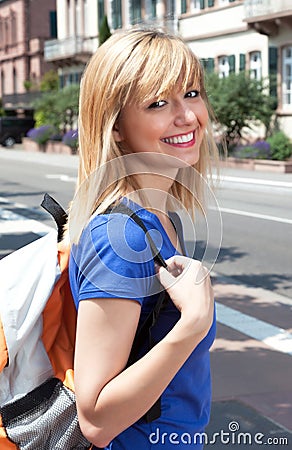 Laughing blonde student with bag in the city Stock Photo