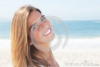 Laughing blonde woman at beach looking at camera Stock Photo