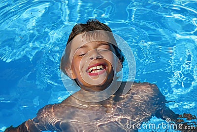 Laughing boy having fun in swimming pool Stock Photo