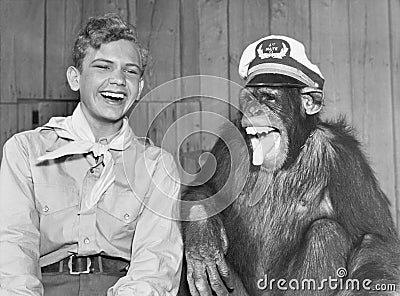 Laughing boy scout and monkey wearing hat Editorial Stock Photo