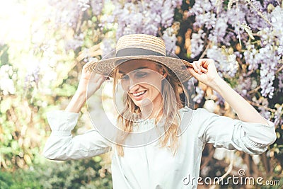 Girl in straw hat and wisteria Stock Photo