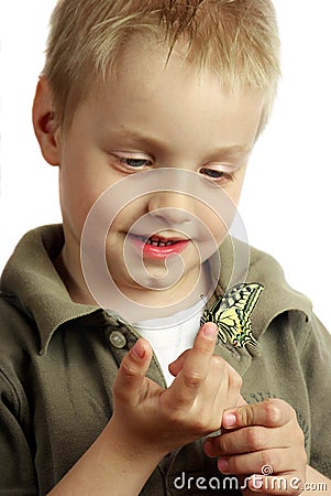 Laughing child. Butterfly sitting on the hand of a child. Child with a butterfly. Selective focus. Stock Photo