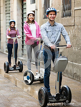 Laughing friends posing on segways on city street Stock Photo