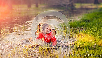 Laughing girl falling in puddle Stock Photo