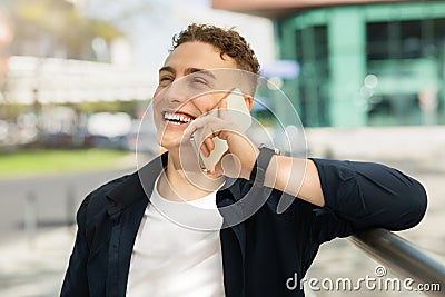 Laughing handsome young european guy enjoy good news, success business, calling Stock Photo