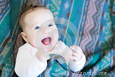 Laughing happy baby under a warm blanket Stock Photo