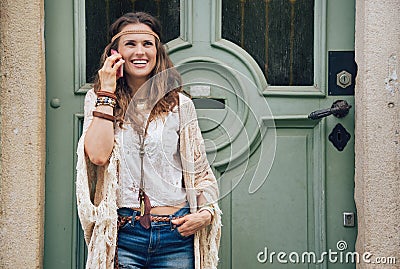 Laughing hippie woman in boho clothes talking cell phone Stock Photo