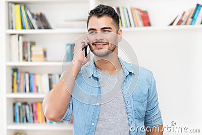 Laughing hispanic hipster man in quarantine talking at mobile phone Stock Photo