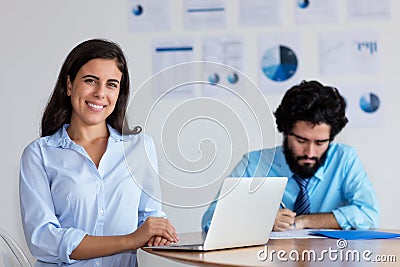 Laughing indian businesswoman and businessman at work Stock Photo