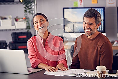 Laughing Male And Female Advertising Marketing Or Design Creatives Collaborating In Studio Stock Photo