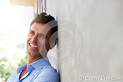 Laughing middle age man leaning against wall Stock Photo