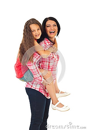 Laughing mother give piggyback to girl Stock Photo