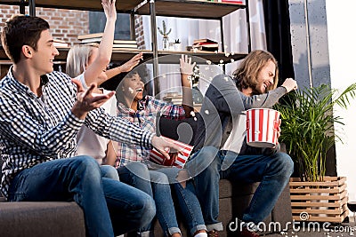 laughing multicultural friends watching tv Stock Photo
