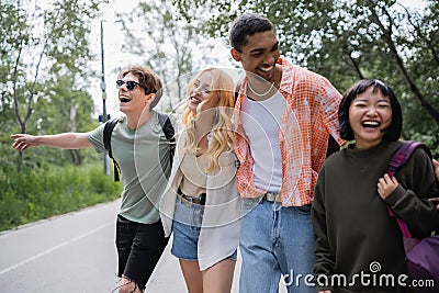 laughing multicultural hitchhikers stopping car on Stock Photo