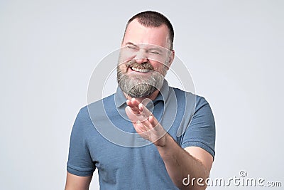 Laughing positive mature guy dressed in blue t-shirt showing stop gesture Stock Photo
