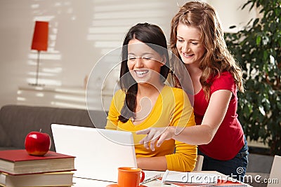 Laughing schoolgirls looking at computer Stock Photo