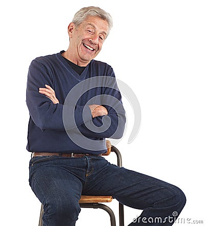 Laughing senior man sitting with arms crossed Stock Photo