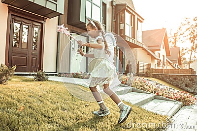 Laughing skinny kid being involved in playing in a mascaraed costume Stock Photo