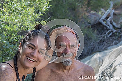 Laughing, smiling, senior mature father with hispanic daughter outside in nature having fun together Stock Photo