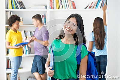 Laughing spanish female student with other international students at library Stock Photo