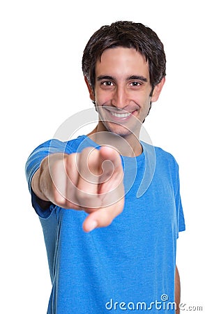 Laughing spanish guy in a blue shirt pointing at camera Stock Photo