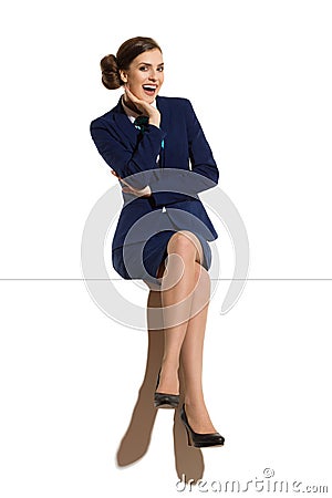 Laughing Stewardess Is Sitting On a Top With Legs Crossed Stock Photo