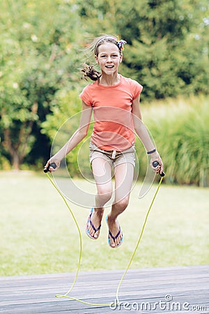 Laughing teenage girl jumping rop Stock Photo