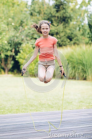 Laughing teenage girl jumping rop Stock Photo