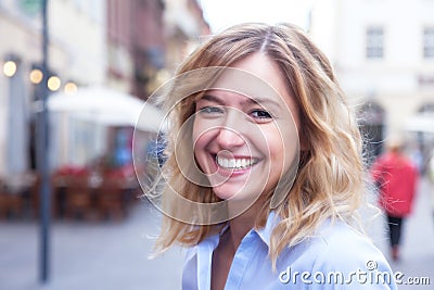 Laughing woman with curly blond hair in the city Stock Photo