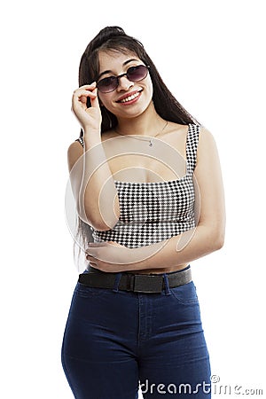 Laughing young girl in jeans. Brunette with long hair wearing sun glasses. Isolated on a white background. Vertical Stock Photo