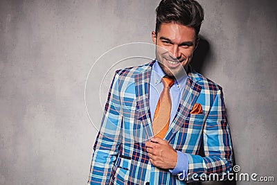 Laughing young man in checkered suit and orange tie Stock Photo