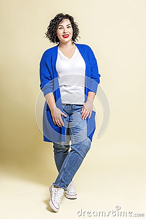 Laughing young woman. Beautiful bright curly brunette in jeans, a white T-shirt and a blue jacket. Positivity and happiness, Stock Photo