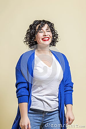 Laughing young woman. Beautiful bright curly brunette in jeans, a white T-shirt and a blue jacket. Positivity and happiness, Stock Photo