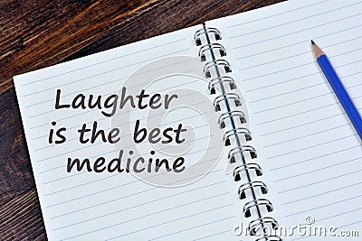 Laughter is the best medicine words on notebook Stock Photo