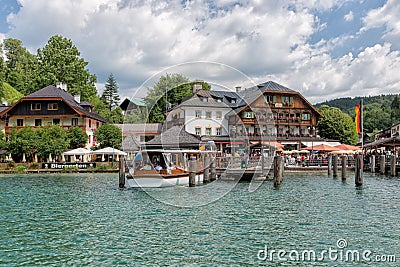 Launch with tourists mooring to wooden pier in lake Konigssee Editorial Stock Photo