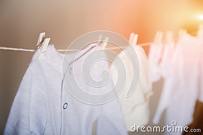 Laundry concept. Cleanliness, ironing, washing of children`s clothes. Baby things dry on a rope close-up and copy space on a gray Stock Photo