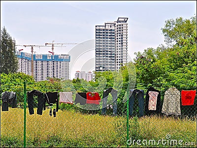 Laundry drying on a fence against an urban background of tall modern new apartment blocks Stock Photo