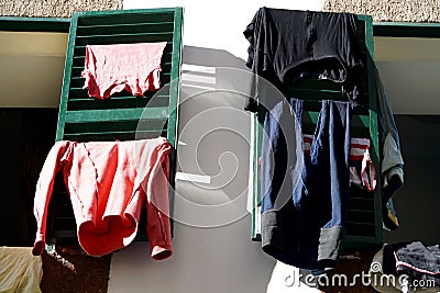 Laundry drying on green folding shutters Stock Photo