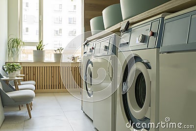 Laundry room interior. Washing machines and dryers in a bright home sunny laundry room. Stock Photo