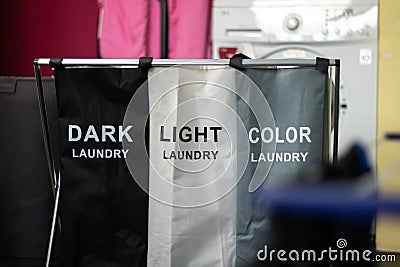 Laundry sorting basket with dark, light, and color laundry Stock Photo