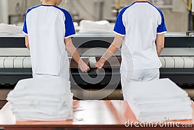 Laundry worker puts ironed textile Stock Photo