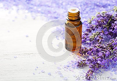 Lavender essential oil, sprigs of lavender and mineral bath salts on the wooden table. Selective focus Stock Photo