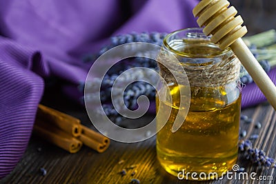 Lavender and herbal honey in glass jar with honey spoon on dark wooden background Stock Photo