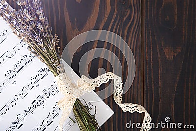 Lavender and paper music notes on old wooden background in vintage style. Stock Photo