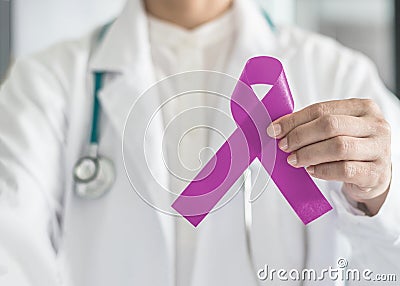 Lavender purple cancer all kinds awareness ribbon on doctor`s hand support for national cancer survivor month campaign Stock Photo