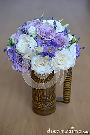 Lavender and roses with purple hues floral arrangement set in a decorated vase with handle Stock Photo