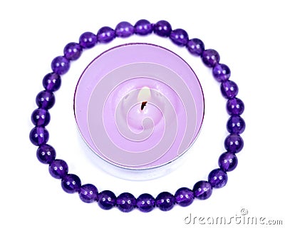 Lavender tea light candle surrounded by royal purple amethyst bead bracelet Stock Photo