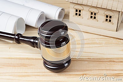 Law and construction concept. Model house, drawings and wooden judge gavel on table . Stock Photo