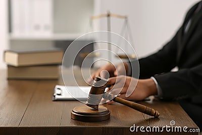 Law and justice. Closeup of judge at wooden table, focus on gavel in office Stock Photo
