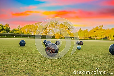 Lawn bowls balls in a field after the game with a colourful sunset Stock Photo